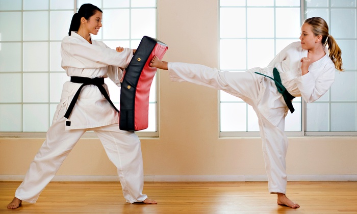 Two women demonstrate a martial arts kick